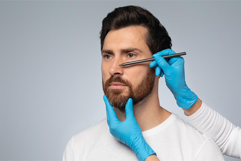 Las manos de un doctor evaluando la nariz del hombre