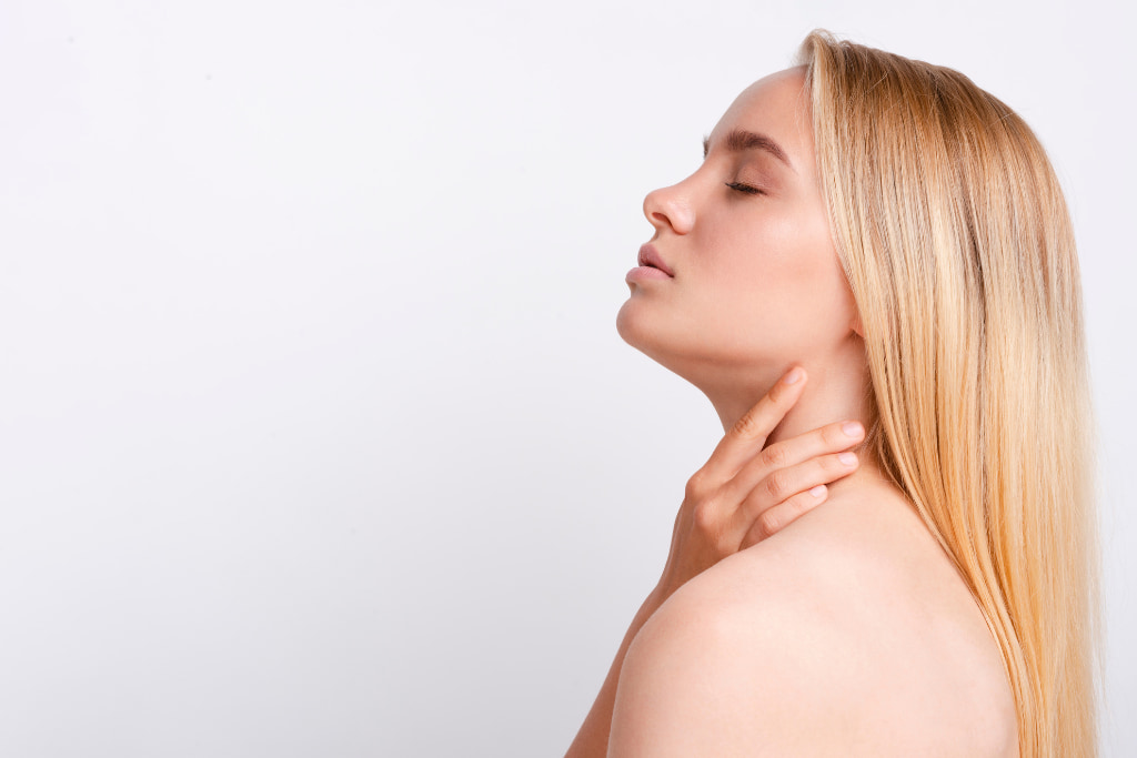 mujer tocándose el cuello y la papada